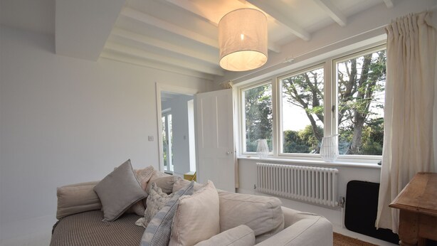 A cozy bedroom with a large window, a radiator, and a wooden table. - Seaside Retreat - Rye Harbour (Rye)