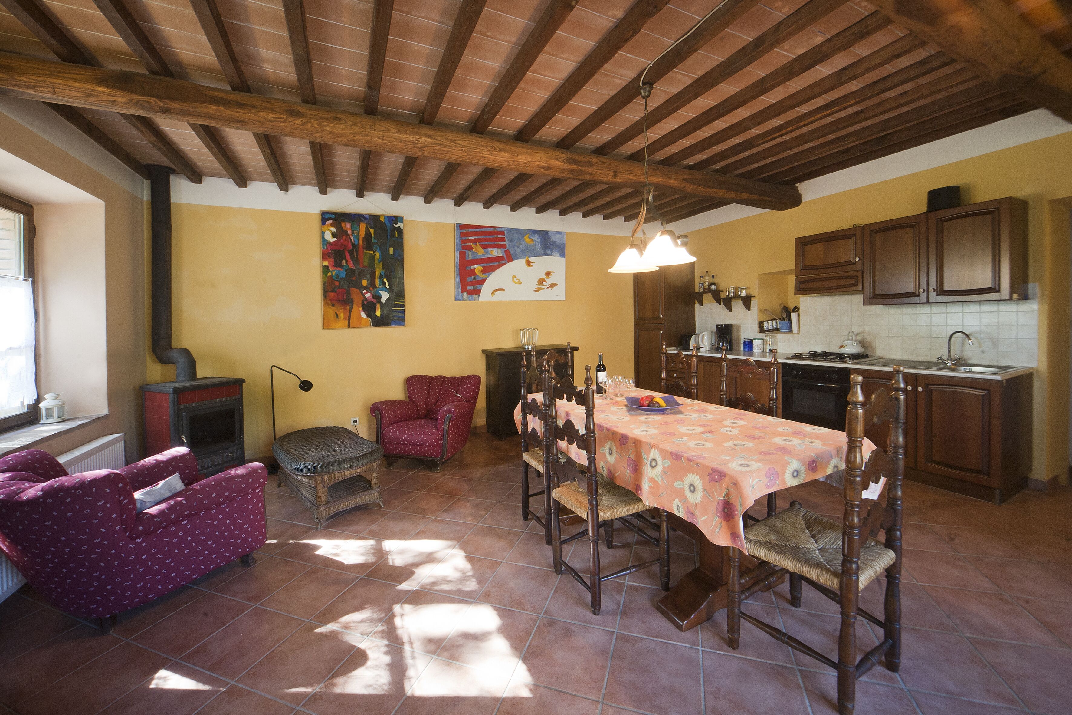 Un grand espace de vie comprenant une table à manger, des chaises, un canapé et une cheminée.