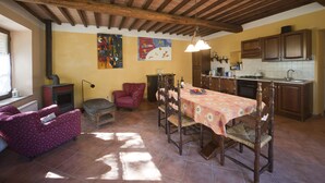Amplia sala de estar con una mesa de comedor, sillas, un sofá y una chimenea.