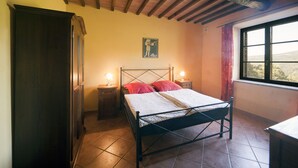 Un dormitorio con cama, mesitas de noche, armario y ventana con vistas.