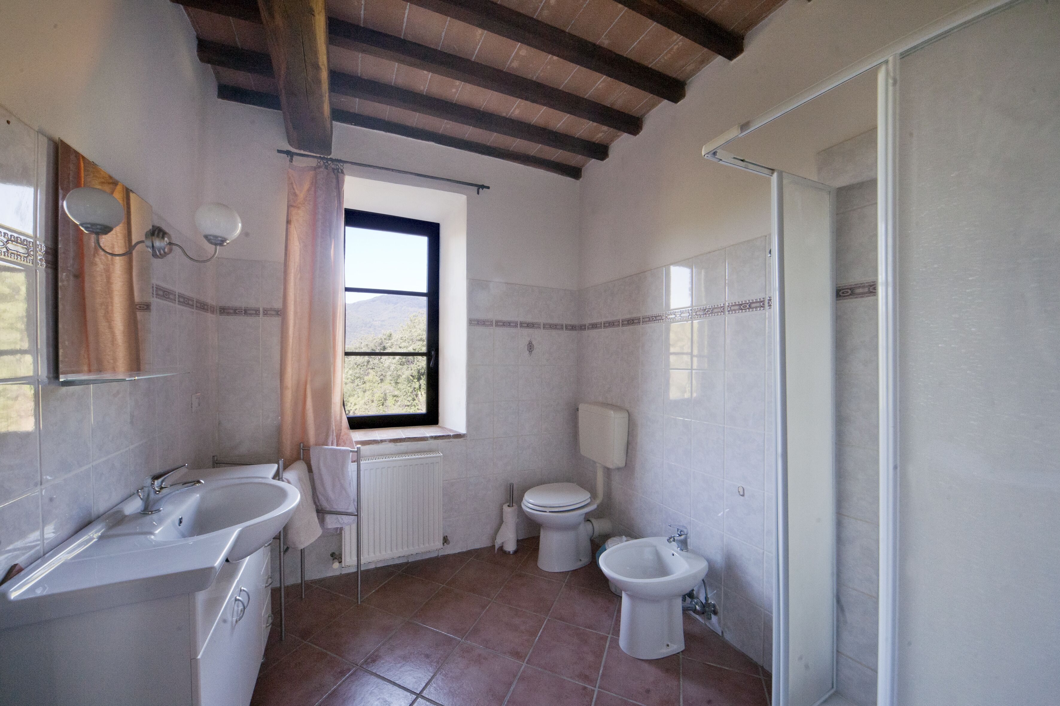 Et badeværelse med badekar, håndvask, toilet og bidét.