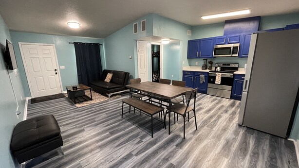 A compact living space with a dining area, kitchenette, and a sofa. - Cheerful 3 Bed home w/ free parking, Wifi, Full Kitchen & Workstation. Sleeps 9 (Orlando)