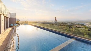 An infinity pool with a clear view of the cityscape and mountains in the background. - Radisson Hotel Nathdwara (Nathdwara)