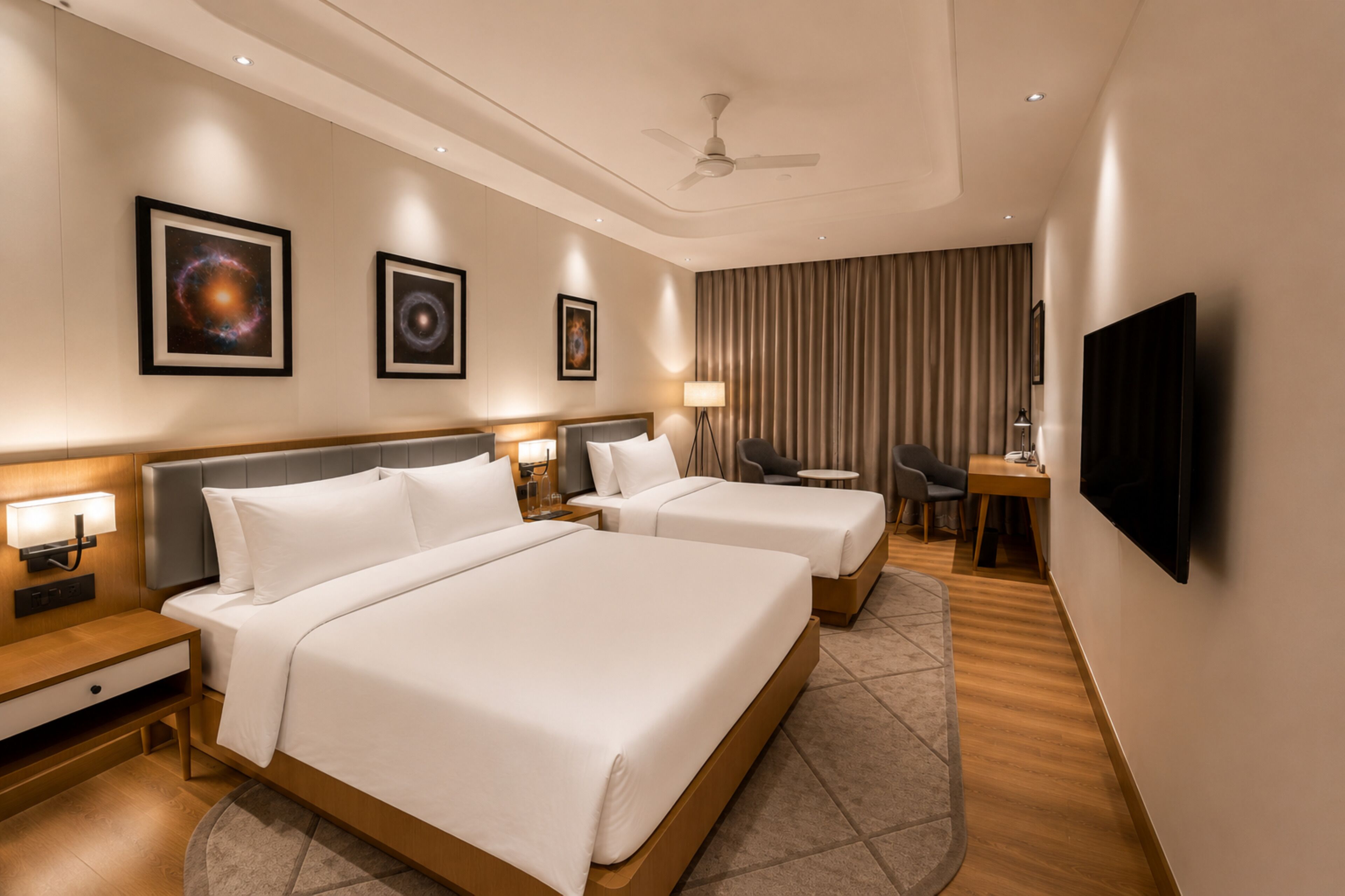 A hotel room with two beds, a desk, a chair, a television, and artwork on the walls.