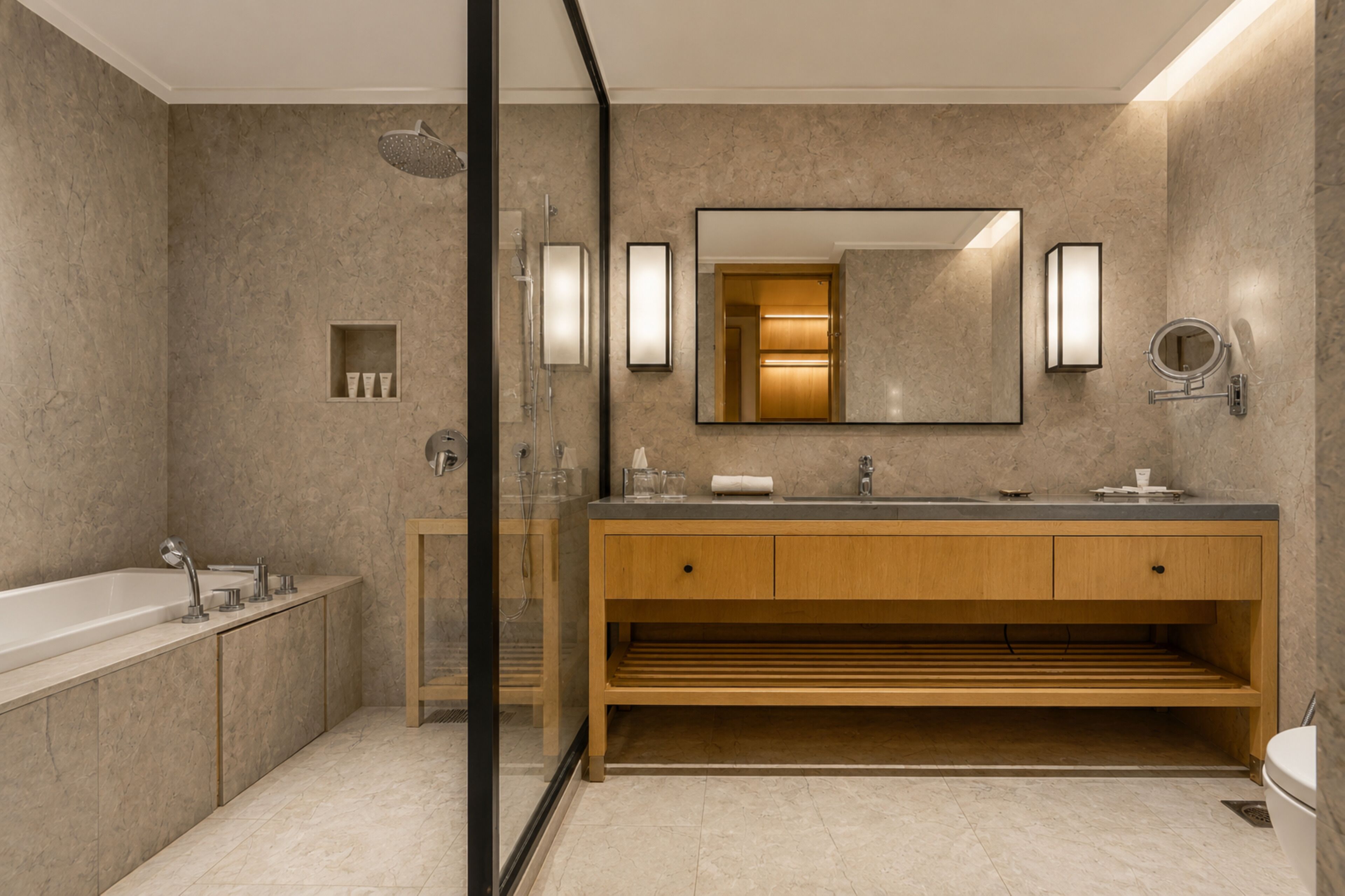 A modern bathroom with a bathtub, a wooden vanity with a mirror, and a shower area.