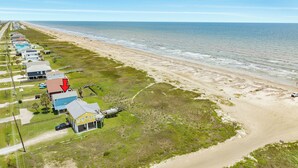 A coastal property with multiple houses, a beach, and a road. - Remodeled Beachfront Home w/ 2 decks & stellar Gulf views - Steps from Beach (Galveston)
