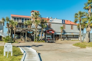 A waterfront building with a red roof, a sign for 'Waterman's Restaurant,' and a dock extending into the water.