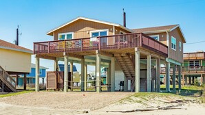 A two-story house with a balcony, a covered porch, and a garage. - Panoramic View Beachfront Home - Easy Beach Access, Outside Shower, Dog Friendly (Galveston)