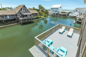 A waterfront property with a wooden deck, lounge chairs, and a view of the water. - Easy Bay Access! Canal Home w/ 2 Decks, 2 Living Areas, Open Plan - Dog Friendly (Jamaica Beach)