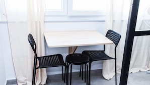 Um quarto pequeno com uma mesa e duas cadeiras.