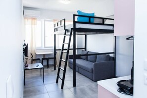 A compact, modern room with bunk beds, a sofa, a small table, and a desk. - Homey studio in Athens Downtown -3 (Athens)