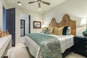 A bedroom with a bed, bedside table, lamp, and a ceiling fan. - 6th Floor Beachfront Condo - Elevator, Private Balcony, Resort Amenities w/ POOL (Galveston)
