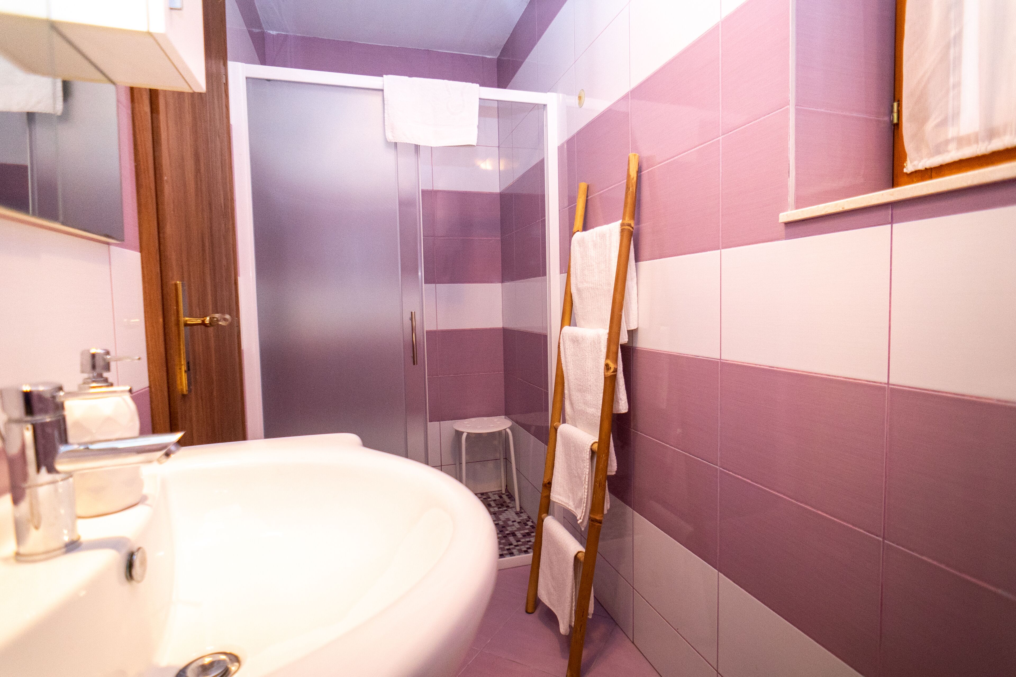 Une salle de bain avec un lavabo blanc, un miroir et un espace douche.