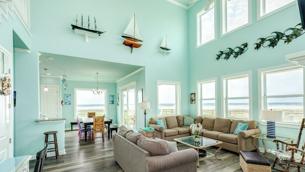 A spacious living room with a large window, a dining area, and a kitchen.