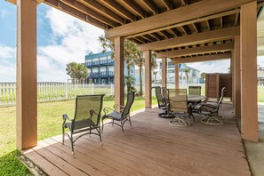 Un patio techado al aire libre con muebles de madera, una mesa y sillas.