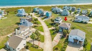 A coastal residential area with houses, a clear sky, and the ocean in the background. - Cozy Beachside Home - Pet Friendly, Fenced Yard, Covered Deck, 0.5 blk to Beach (Galveston)
