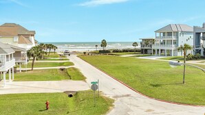 Eine Wohnstraße mit Häusern, einem Hydranten, einem Stoppschild und Blick auf das Meer.