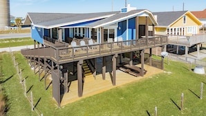 A beachfront house with a balcony, outdoor seating, and a covered deck area. - Updated Beachfront Home w/ Elevator+Ramp, 2 Primary Suites, Great Gulf Views (Galveston)