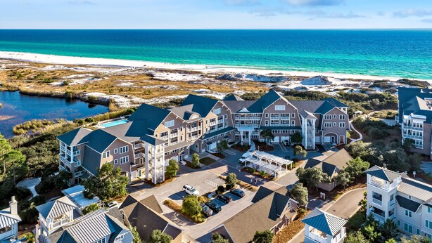 Un hôtel situé sur la côte, composé de plusieurs bâtiments, doté d’un parking et offrant une vue sur la plage.