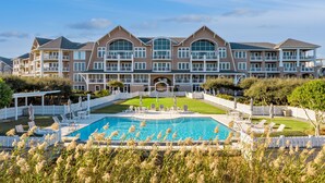 Un grand hôtel doté d’une piscine, de nombreux balcons et d’une pelouse bien entretenue.