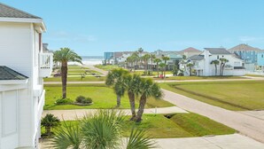 Un barrio residencial con casas, una acera y una carretera que lleva a la playa.