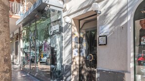 A storefront with a glass facade, a mannequin dressed in winter clothing, and a sign indicating the sale of winter clothing.