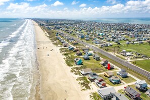 Une zone résidentielle côtière, avec des maisons construites le long de la plage et une route qui longe le littoral.