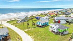A coastal residential area with houses, a beach, and a road. - Willy's Place: 3rd Row Gulf View Home with Updated Interior & Rooftop Sun Deck (Galveston)