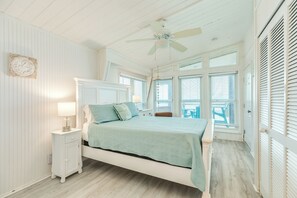 A bedroom with a bed, nightstand, and a ceiling fan. - Panoramic Gulf Views @ Beachfront Home w/ Updated Interior, Free Wifi (Galveston)