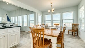 Una cocina amplia con una isla grande, sillas de madera y una decoración náutica.