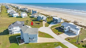 Een kustgebied met huizen, een strand en een heldere lucht.