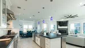 A modern kitchen with a large island, built-in appliances, and pendant lighting. - 2nd Row Dog Friendly Home w/ Gulf views, 2 Decks, Screened Area (Galveston)
