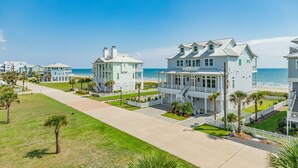 A beachfront property with multiple houses, a well-maintained lawn, and a clear view of the ocean. - 2nd Row Dog Friendly Home w/ Gulf views, 2 Decks, Screened Area (Galveston)