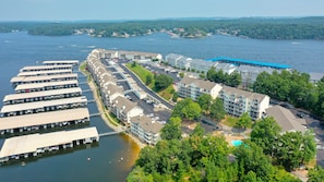 A marina with docked boats, a swimming pool, and a view of the surrounding water and hills.