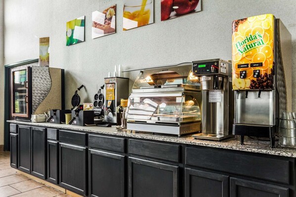 A self-service beverage station with a Florida's Natural drink dispenser, a waffle maker, and a coffee machine. - Quality Inn Clare (Clare)