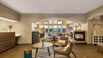 A spacious living area with a fireplace, comfortable seating, and a reception desk.