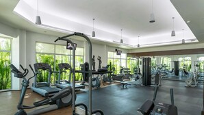 Ein Fitnessstudio mit Laufbändern, Kraftgeräten und einer Spiegelwand.