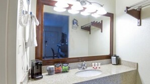 Une salle de bain équipée d’un lavabo, d’une machine à café et d’articles de toilette.