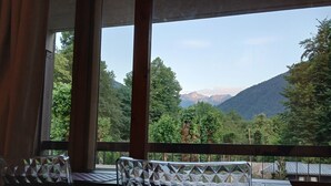 Habitación con vista a un paisaje montañoso a través de grandes ventanales.