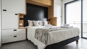 A modern bedroom with a bed, nightstands, and a large window. - Hotel Résidence a Torra (Vescovato)