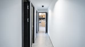A narrow hallway with a kitchen at the end. - Hotel Résidence a Torra (Vescovato)