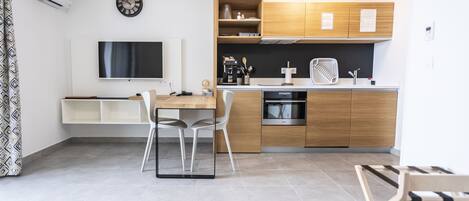 Una cocina moderna con horno empotrado, cafetera y armarios de madera.