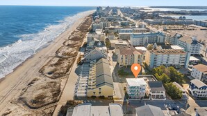 Vue aérienne d’une ville côtière avec des propriétés situées en bord de mer, dont un hôtel dont l’emplacement est clairement indiqué.