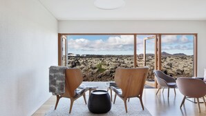 A modern interior with a large window offering a desert view. - Silica Hotel (Grindavík)