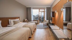 Ein Hotelzimmer mit zwei Betten, einem großen Spiegel, einem Fernseher und Blick ins Freie.
