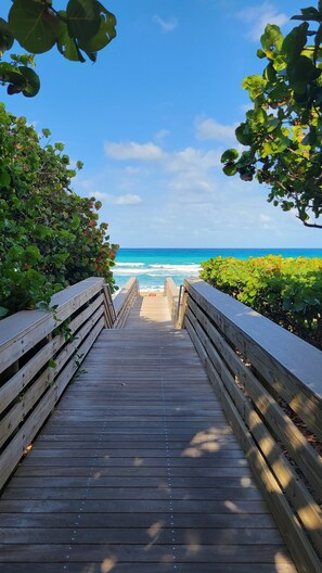 A wooden boardwalk leading to a beach with ocean views. - Lakefront Home with Large Pool, Hot Tub & Near the Beach (lake worth)