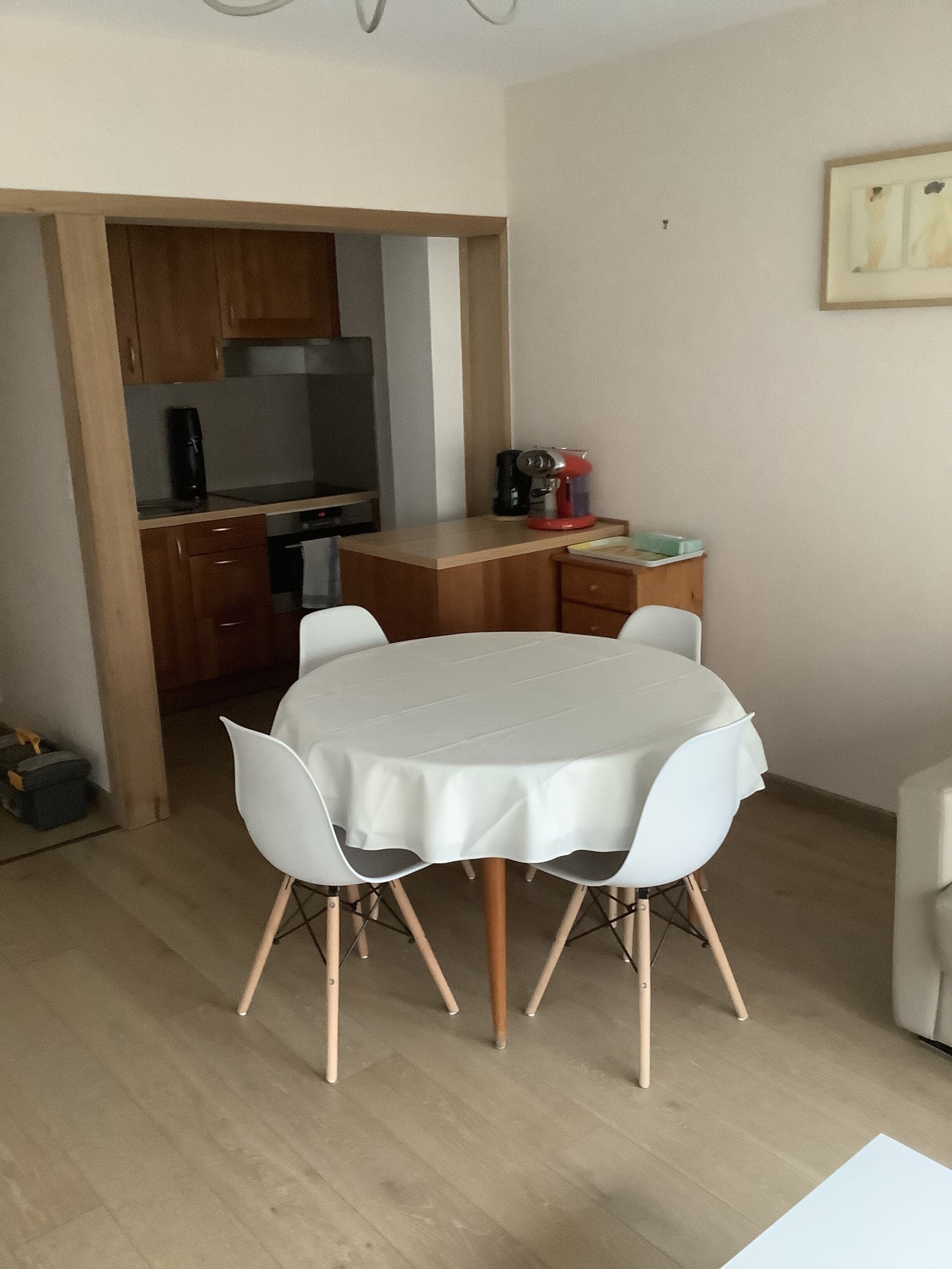 Un espacio habitable compacto con una mesa de comedor, sillas, una kitchenette y un pequeño sofá.