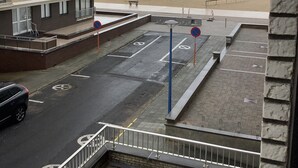 A parking area with a view of the beach and a building with multiple windows and balconies. - Sun-oriented studio Sint-Idesbald with beautiful sea view (Koksijde)