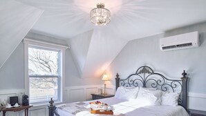 Une chambre à coucher avec un lit, une table de chevet, une lampe et un lustre.