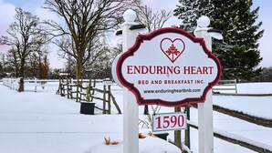 Une enseigne pour l’établissement Enduring Heart Bed and Breakfast Inc., avec un symbole en forme de cœur et l’adresse 1590.